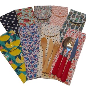 May include: A set of eight reusable cutlery sets in various patterned fabric pouches. Each set includes a fork, knife, and spoon. Some sets feature wooden utensils, while others have stainless steel utensils with red handles.