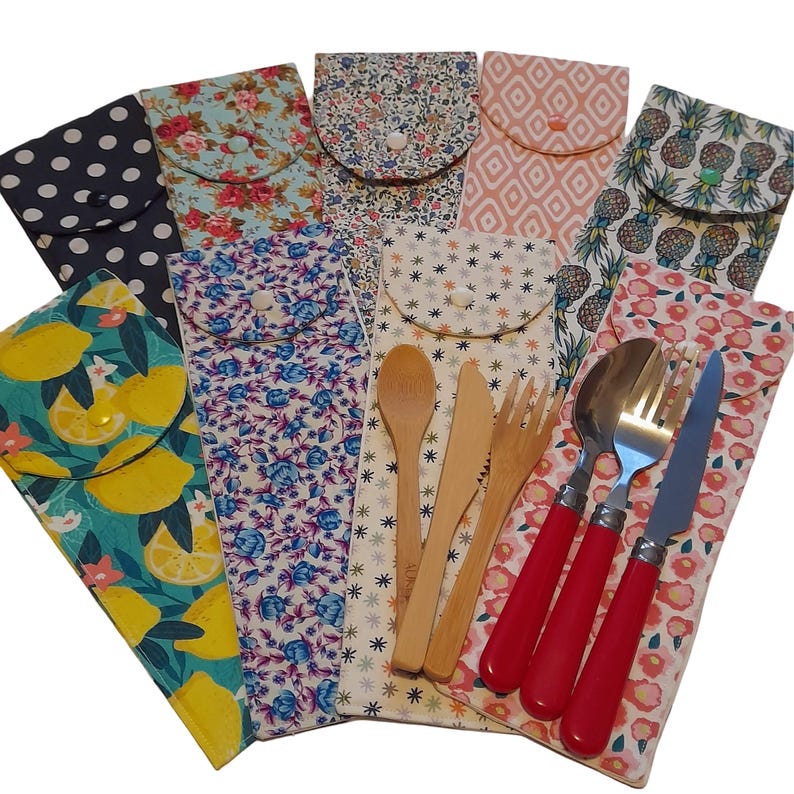May include: A set of eight reusable cutlery sets in various patterned fabric pouches. Each set includes a fork, knife, and spoon. Some sets feature wooden utensils, while others have stainless steel utensils with red handles.