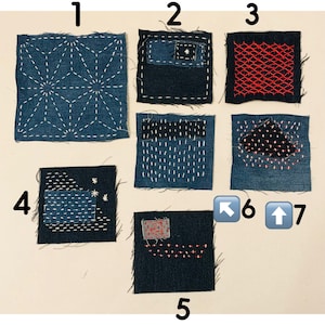 May include: Seven denim fabric squares with hand-stitched patterns. The squares feature white and red thread designs, including geometric and abstract patterns. The denim is a deep indigo colour, with various stitch styles.