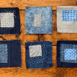 May include: Six square fabric patches with different stitching patterns. The patches are made of denim and linen fabrics in shades of blue and beige.