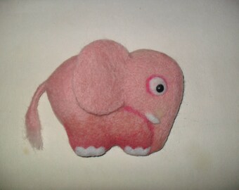 May include: A pink felt elephant with a black eye and a white felt trunk.