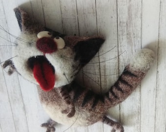Può includere: Un gatto di feltro marrone e bianco con una lunga coda a strisce. Il gatto ha un'espressione sorpresa con la bocca aperta e la lingua di fuori. Il gatto è fatto di lana e ha un aspetto realistico.