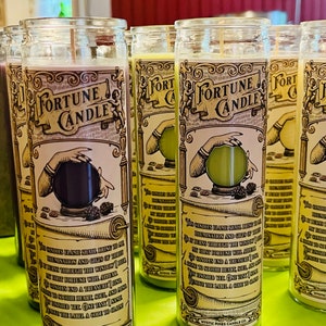 May include: A set of six glass fortune candles with a vintage design. Each candle features a hand holding a crystal ball with a different color inside. The candles are labeled "Fortune Candle" and have a text description on the side.