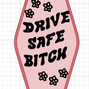 May include: Pink motel key tag with black text that reads "DRIVE SAFE BITCH" and black flower accents.