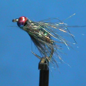 May include: A close-up of a fly fishing lure with a red and iridescent bead head, silver body, and gray and silver marabou feathers.