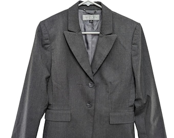 May include: A gray pinstripe blazer with two buttons and two front pockets. The blazer is hanging on a white hanger. The label reads "Tahari ASL".