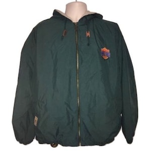 May include: A dark green hooded jacket with a zipper closure and a fleece lining. The jacket has a logo on the front that says "Chicago Bulls".