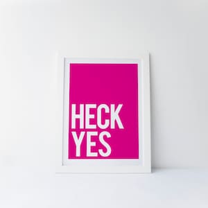 May include: White framed print with a bright pink background and the text "HECK YES" in white.