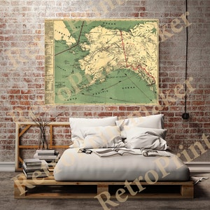 May include: A vintage map of Alaska with a green background and red lines showing the route of the Alaska Railroad. The map includes text labels for various locations and geographic features.