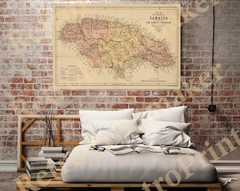 May include: A vintage map of Jamaica, printed on aged paper, with a detailed outline of the island's parishes and surrounding waters. The map is titled "Map of the Island of Jamaica" and includes the text "The Jamaica Handbook 1895". The map is framed and hanging on a brick wall above a bed with white linens and a book.