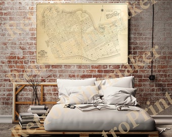 May include: A vintage map of Key West, Florida, printed in black and white on a cream-coloured background. The map is framed and hanging on a brick wall above a bed with white bedding.