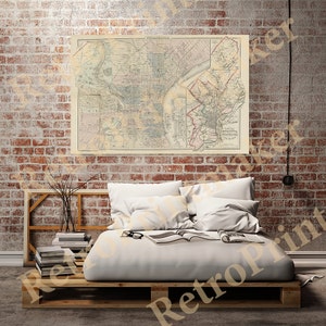 May include: A vintage map of Philadelphia, Pennsylvania, printed in black and white with red accents. The map is framed and hanging on a brick wall above a white bed with white bedding and pillows.