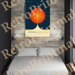 May include: A bedroom with a bed and a poster. The poster has a dark blue background with a large orange circle and the text "DEEP SPACE ATOMIC CLOCK". The bed has a gray comforter and two pillows. The wall behind the bed is made of wood.