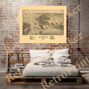 May include: An antique map of Cedar Key, Florida, from 1889. The map is a bird's-eye view of the town, showing the streets, buildings, and waterfront. The map is printed in black and white on a cream-colored background.