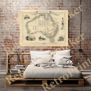 May include: An antique map of Australia from 1850, showing the different states and territories. The map is printed on a cream-colored paper with brown and black ink. The map is framed and hanging on a brick wall.