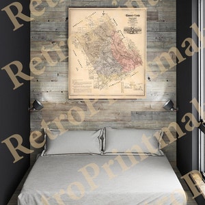 May include: A vintage map of Erath County, Texas, displayed above a bed with gray bedding. The map is framed and features detailed cartography with various colors. The bedroom has a rustic wooden wall and a modern design.