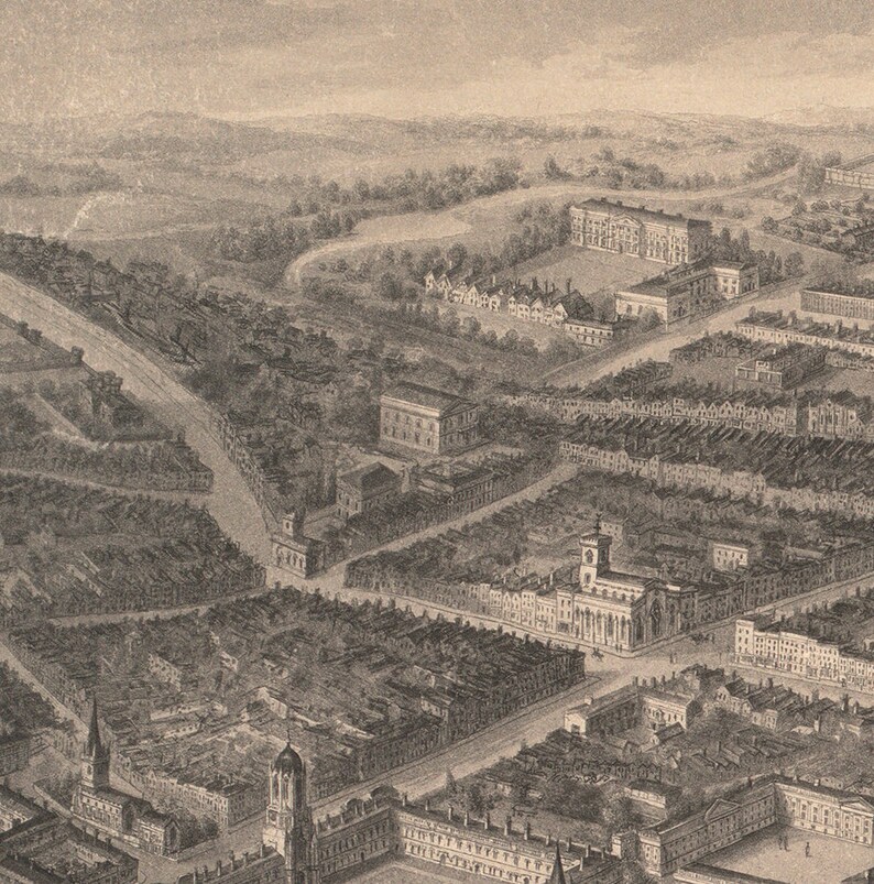 May include: An aerial view of a city with a large building in the center. The building has a tall spire and is surrounded by smaller buildings. The city is laid out in a grid pattern with streets running in all directions.