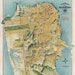 May include: A vintage map of San Francisco, California, in yellow, green, and blue colors. The map is titled 'The Chevalier Original Map of San Francisco' and includes the text '1915 - The Exposition City - 1915.' The map shows the streets, parks, and bodies of water of the city.