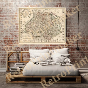 May include: An antique map of Switzerland, printed in black and white with hand-colored details. The map shows the borders of the cantons and surrounding countries. The map is framed and hanging on a brick wall above a bed.