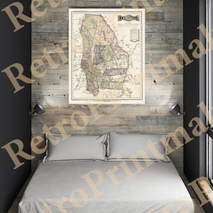 May include: An antique map of the state of Chihuahua, Mexico, printed on paper and framed in a wooden frame. The map is displayed on a wall above a bed with white bedding.