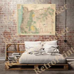 May include: A vintage map of the state of Oregon, printed on paper with a cream background. The map shows the state's counties, cities, and major roads. The map is framed and hanging on a brick wall above a bed with white bedding.