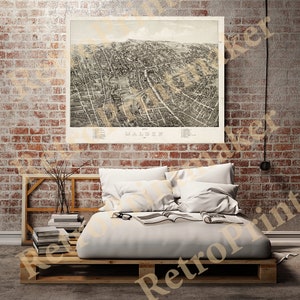 Puede incluir: Un mapa aéreo vintage de Malden, Massachusetts. El mapa está impreso en blanco y negro y muestra las calles, edificios y parques de la ciudad. El mapa está enmarcado y colgado en una pared de ladrillo.