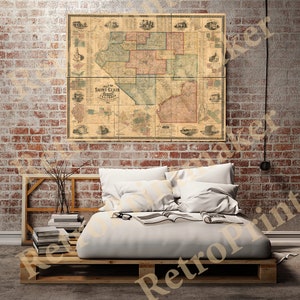 May include: A vintage map of Saint Clair County, Illinois, printed on paper with a brown background. The map shows the county's townships and roads. The map is framed and hanging on a brick wall.