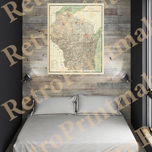 Puede incluir: Un mapa vintage del estado de Wisconsin, impreso en blanco y negro con acentos rojos y verdes. El mapa está enmarcado y colgado en una pared de madera con paneles sobre una cama blanca con dos almohadas.