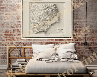 May include: A vintage map of the Carolina coastline, printed in black and white on cream paper. The map is framed and hanging on a brick wall above a bed with white bedding.