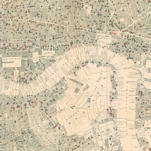 May include: An antique map of London, England, with red and blue markings indicating locations. The map shows the River Thames, the Tower of London, and other landmarks. The map is printed on a cream-colored paper with black text.