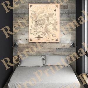 Puede incluir: Un mapa vintage de Flushing, Nueva York, impreso en blanco y negro sobre papel crema. El mapa está enmarcado y colgado en una pared de madera sobre una cama con sábanas blancas.