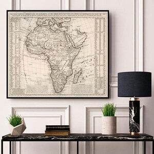 Puede incluir: Un mapa vintage de África en blanco y negro con un marco negro. El mapa está titulado "Nouvelle Carte de L'Afrique ou de la Nigritie et des Isles Voisines, Avec Les Differentes Routes de Mer, etc."