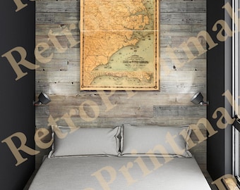May include: A vintage map of the State of South Carolina, printed in brown and black ink on cream-coloured paper. The map shows the state's counties, rivers, and major cities. The map is framed and hanging on a wall in a room with a bed and wooden walls.