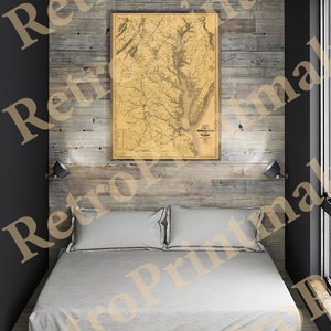 Puede incluir: Un mapa vintage de Virginia y Maryland, enmarcado y colgado en una pared de madera con paneles de madera sobre una cama con sábanas blancas.