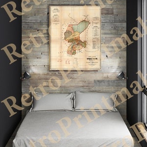May include: A vintage map of the Dominican Republic, printed on paper, framed in a simple wooden frame, hangs on a wood-paneled wall above a white bed with two pillows.