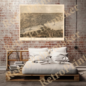 Puede incluir: Un mapa antiguo de la ciudad de Pittsburg, Pensilvania, impreso en blanco y negro con un tono sepia. El mapa muestra las calles, los edificios y las vías fluviales de la ciudad. El mapa está enmarcado y colgado en una pared de ladrillo.