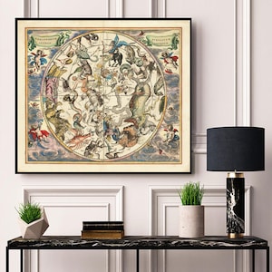 Puede incluir: Una ilustración vintage de un mapa celestial que representa constelaciones con el texto latino "Stellarium Antiquum" y "Constellatio Australis" en la parte superior. El mapa está rodeado por un marco negro y se coloca contra una pared blanca.