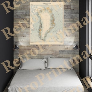 Puede incluir: Un mapa vintage de Groenlandia, impreso en papel, está enmarcado y colgado en una pared sobre una cama con ropa de cama blanca. La pared está hecha de tablones de madera.