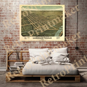 May include: An antique bird's eye view map of Circleville, Pickaway County, Ohio. The map is printed in brown, green, and blue ink on a cream-coloured paper. The map shows the layout of the city with streets, buildings, and a river.