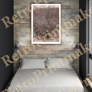 Peut inclure: Une carte vintage encadrée de Tallahassee, en Floride, accrochée à un mur lambrissé de bois au-dessus d'un lit blanc avec deux oreillers. Le lit se trouve dans une petite pièce avec une fenêtre et un mur noir.