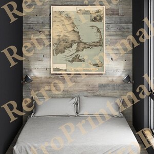 May include: A vintage map of Nantucket to Boston, framed and hanging on a wooden wall above a bed with white bedding. The map is in shades of brown, blue, and green.
