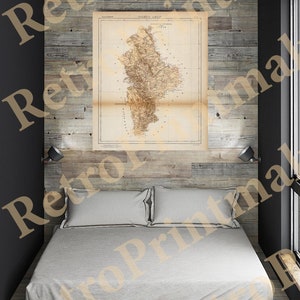 May include: A vintage map of the island of Mallorca, Spain, printed on aged paper with a brown and white color scheme. The map is framed and hanging on a wood-paneled wall above a bed with white linens.