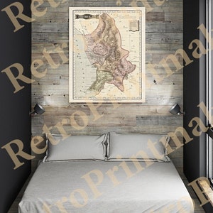May include: A vintage map of the County of Cork, Ireland, printed in black and white with hand-colored details. The map is framed and hanging on a wood-paneled wall above a bed with white linens.
