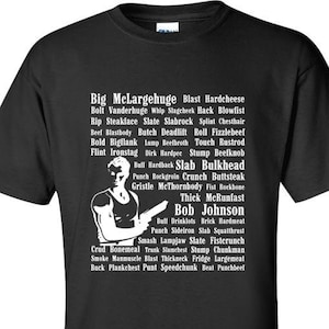 Op de afbeelding: Zwart T-shirt met een witte grafische print van een mannengezicht en een lijst met woorden, waaronder "Big McLargehuge", "Blast Hardcheese", "Bob Johnson" en "Thick McRunfast".
