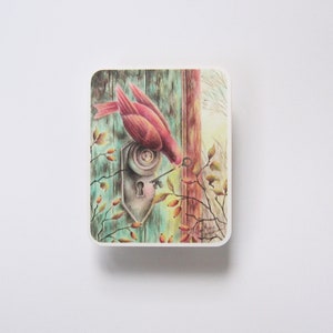 May include: A watercolor painting of a red bird perched on a door knob with a key in its beak. The door is painted in shades of blue and green, with a wooden frame. The background is a soft, muted green.