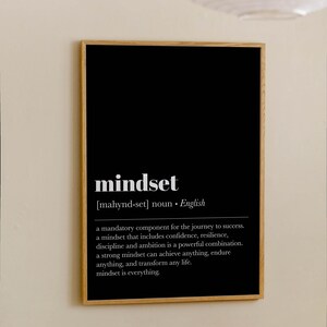 K&ouml;nnte beinhalten: Ein gerahmter Druck mit schwarzem Hintergrund und dem Wort "mindset" in Wei&szlig;. Die Definition von "mindset" steht unter dem Wort. Der Rahmen besteht aus Holz und h&auml;ngt an einer beigefarbenen Wand.
