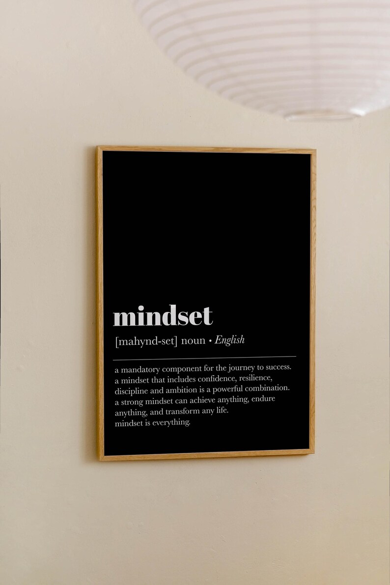 K&ouml;nnte beinhalten: Ein gerahmter Druck mit schwarzem Hintergrund und dem Wort "mindset" in Wei&szlig;. Die Definition von "mindset" steht unter dem Wort. Der Rahmen besteht aus Holz und h&auml;ngt an einer beigefarbenen Wand.