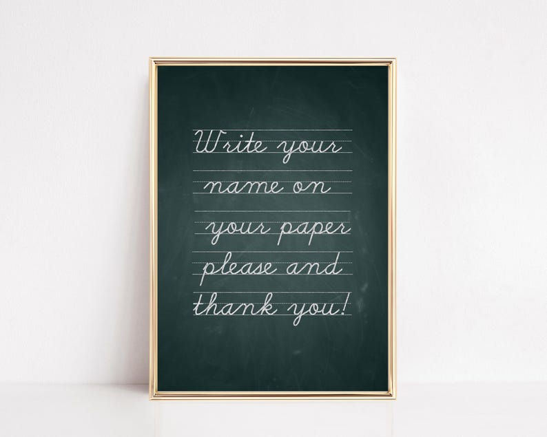 May include: A framed chalkboard with a gold border. The chalkboard has a dark green background with white cursive text that reads "Write your name on your paper please and thank you!"
