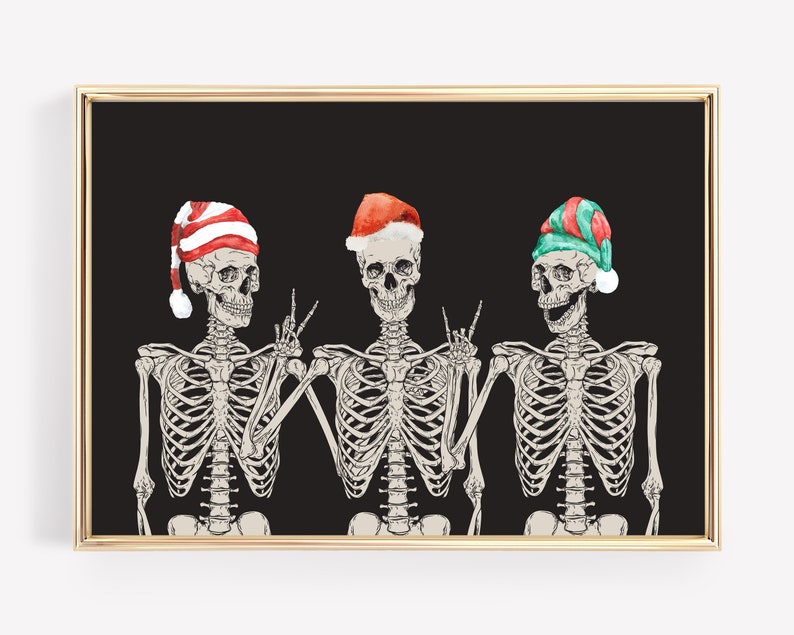 May include: A framed wall art print featuring three skeletons against a solid black background. The skeletons wear festive hats: one in red and white stripes, one in red with a white trim, and one in green and red. They pose with hand gestures.