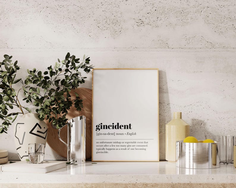 Peut inclure: Une affiche encadr&eacute;e avec le mot "gincident" et sa d&eacute;finition. L'affiche est sur une surface blanche avec un pichet en acier inoxydable, un verre et un vase d&eacute;coratif. Des branches vertes et feuillues sont &agrave; gauche.